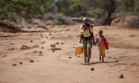 Consolata and her daughter Elizabeth carry jerry cans from a watering hole during drought in Kenya in 2017