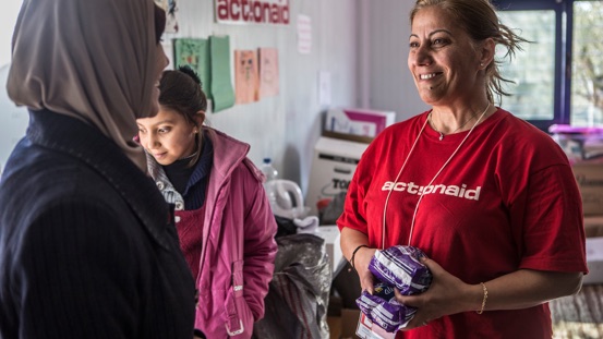 An ActionAid worker distributes sanitary towels in a woman safe space.