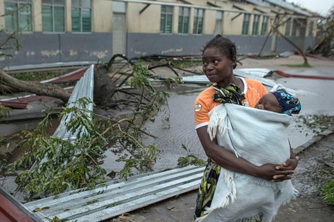 Woman holding baby almost hit by falling tree and building during Cyclone Idai in Mozambique in March 2019
