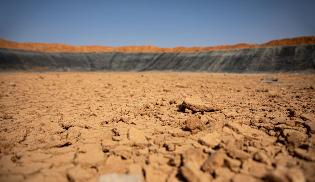 Once filled with over 150,000 barrels of water, this ActionAid-implemented earth dam in Somaliland is now completely dry due to drought.