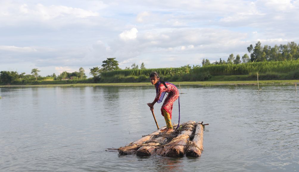 Adori, 13, has to cross flood water to attend school in her village in Bangladesh.