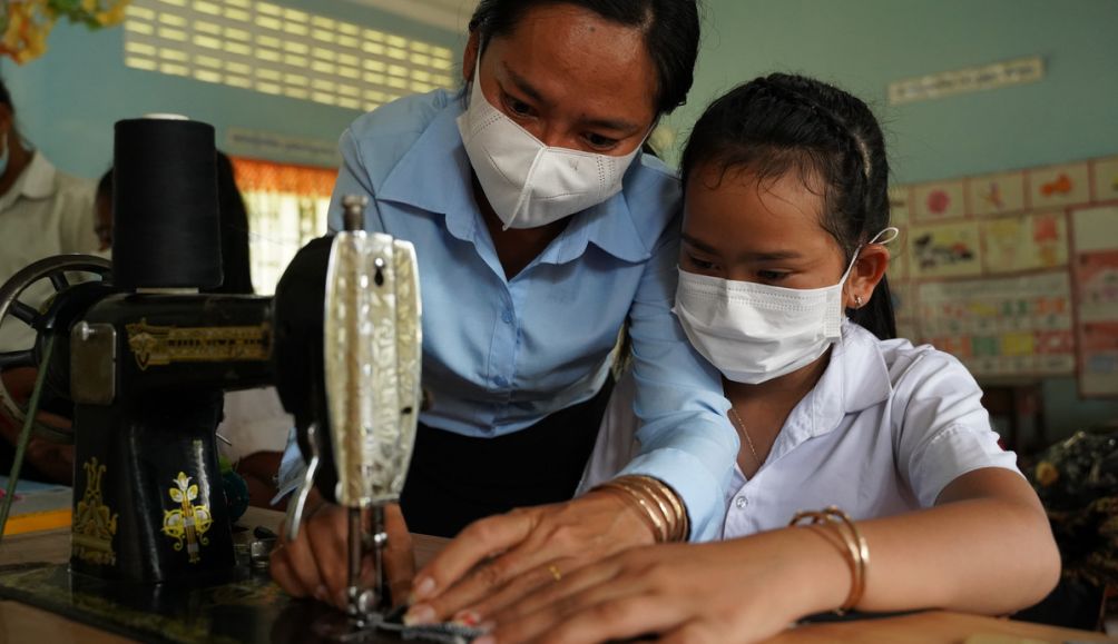 Ouk, aged 12, and her teacher Bou Sokunthy during a tailoring class at a primary school in rural Cambodia