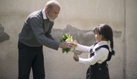 Six-year-old Maria helps out a local gardener at the ActionAid centre in Zarqa, Jordan. 