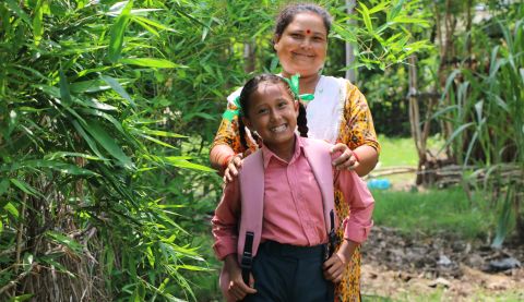 A mother and a child smiling at the camera