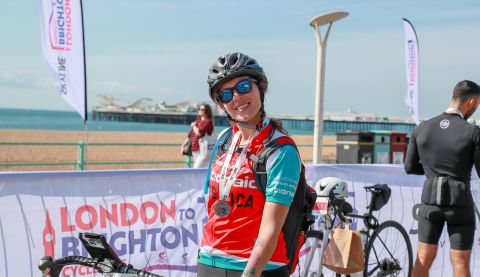 ActionAid supporter Jessica smiles after collecting her medal at the London to Brighton Cycle, 2024.