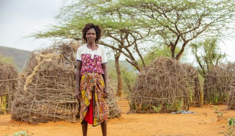 Woman standing in front of some huts