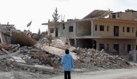 A woman with her back to camera looking at the destruction in Lebanon.