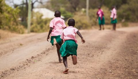 Two girls making their way to school in Kenya. Many girls living in poverty are subject to catcalling and street harassment on their way to and from school