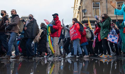 Photo of a protest march in Glasgow passing in front of a large puddle