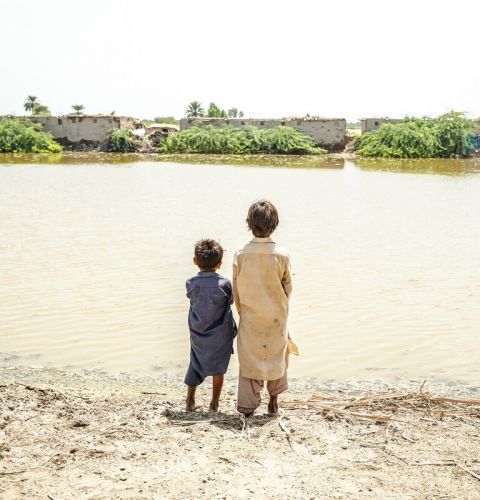 Pakistan floods appeal 2022 - Children look across the floodwaters in Sindh province, Pakistan, where millions of people need urgent help.