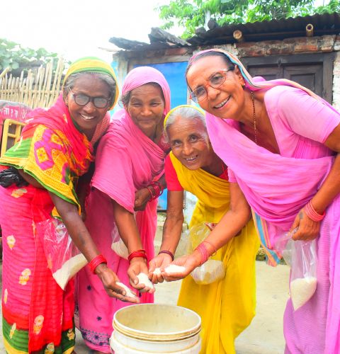 Women's groups in Nepal collect rice to help families in need.