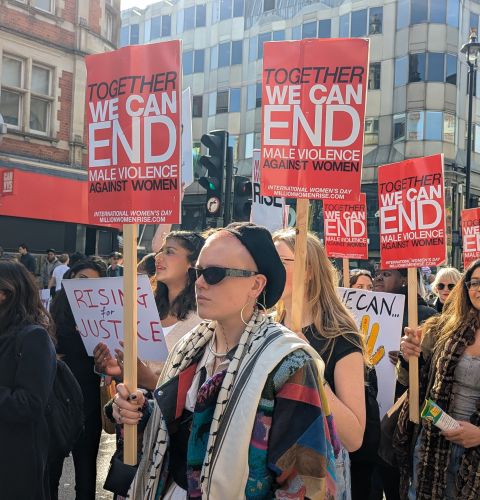 ActionAid at women's march holding placards