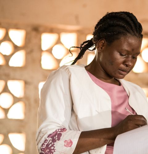 A teacher signing a copy book
