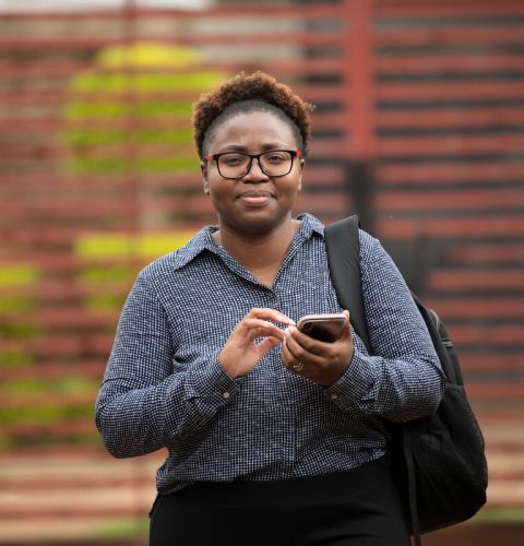 A woman holding a phone and tapping on it