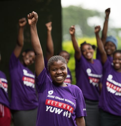 Young women smiling and raising their fists in the air.
