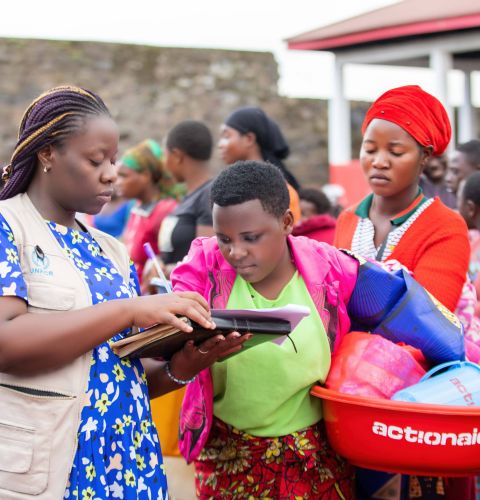 A woman distributing hygiene kits to displaced women in the DRC
