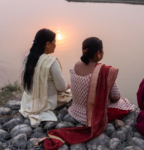 women looking over at the river with their backs to us