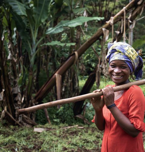 Farmer holding a spade and posing for the camera.