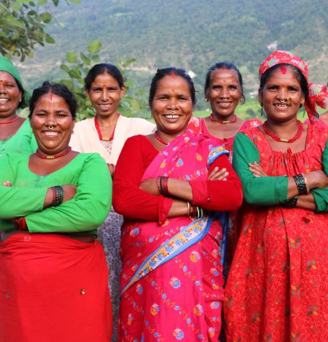 Group of Nepalese women standing with their arms folded and smiling.