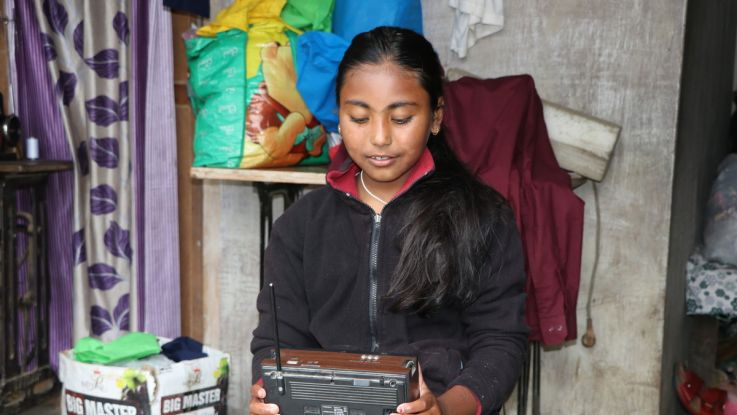 Girls listen to radio to catch up on lessons in Nepal