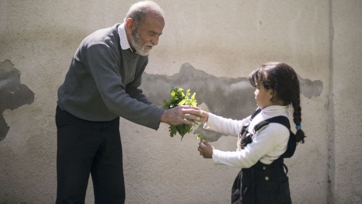 Six-year-old Maria helps out a local gardener at the ActionAid centre in Zarqa, Jordan. 