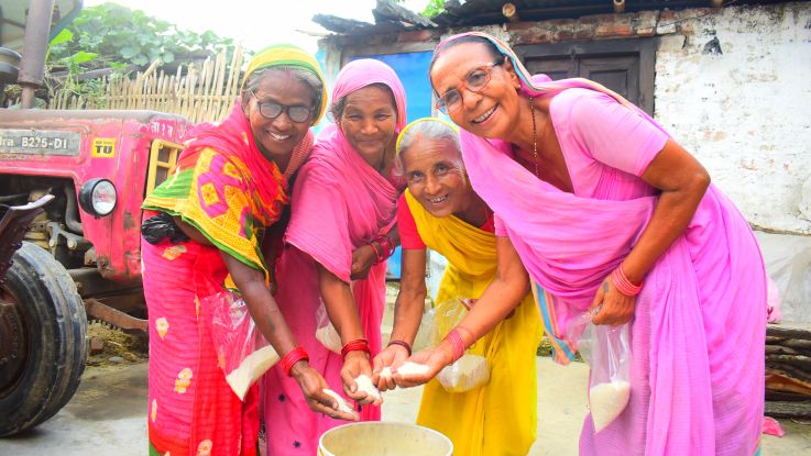 Women's groups in Nepal collect rice to help families in need.