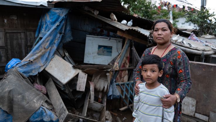 Anju and one of her children outside their destroyed home