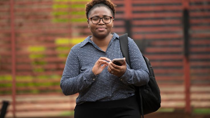A woman holding a phone and tapping on it