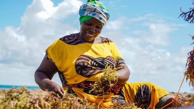 Woman happily farming and smiling down at earth