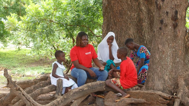 Woman and children sat under a tree