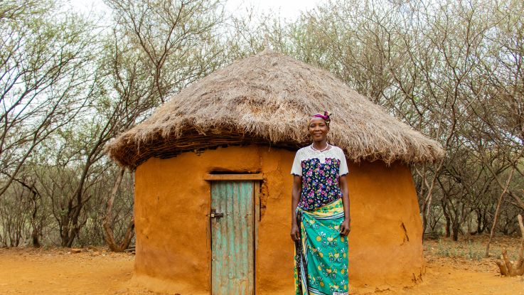 woman standing in front of a hut