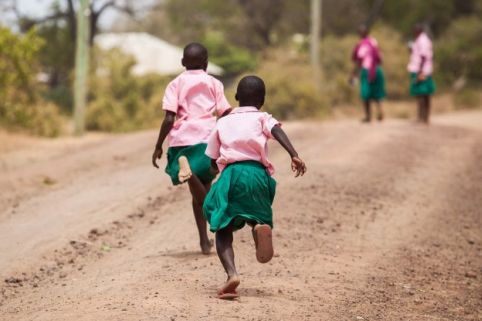 Two girls making their way to school in Kenya. Many girls living in poverty are subject to catcalling and street harassment on their way to and from school