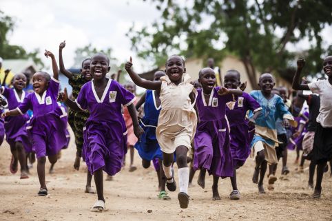 Girls running outside at the a girls' primary school in Uganda.